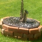 saxophone fountain, alto saxophone, bricks, grass, river rocks