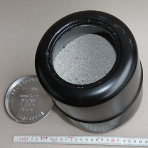 burial capsule from Germany human cremains, traditional German burial capsule, black round capsule, grey sand-like cremains